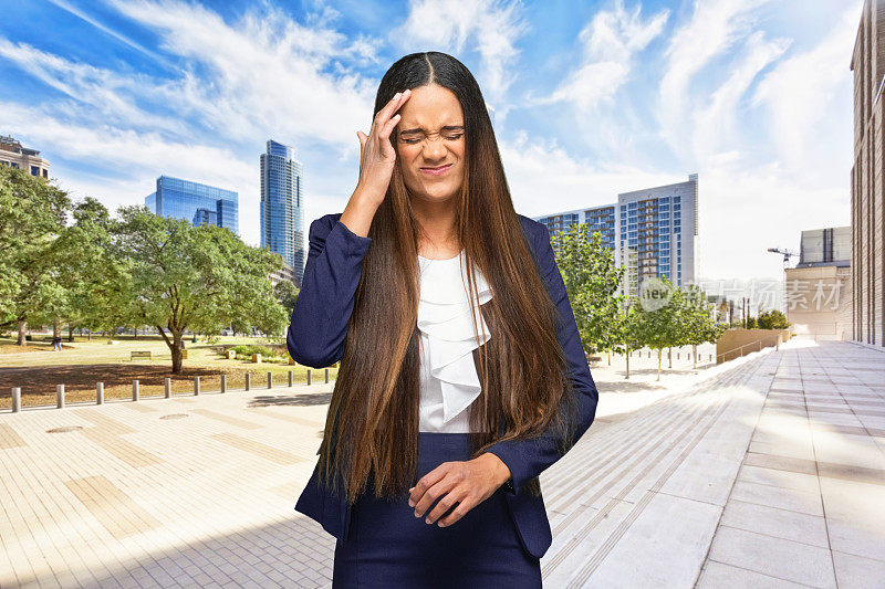 正面视图/看相机/腰部以上/肖像/一个美丽的非洲裔/非洲裔女性/年轻女性商人/女商人/经理站在户外穿着西装和持有美国